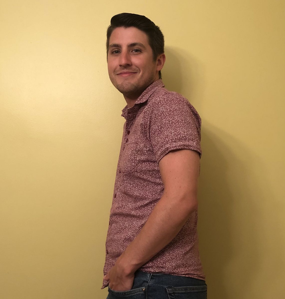 Portrait of a person smiling over their left shoulder